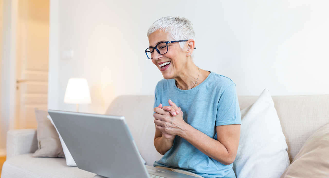 Happy senior on laptop visiting an online dating site