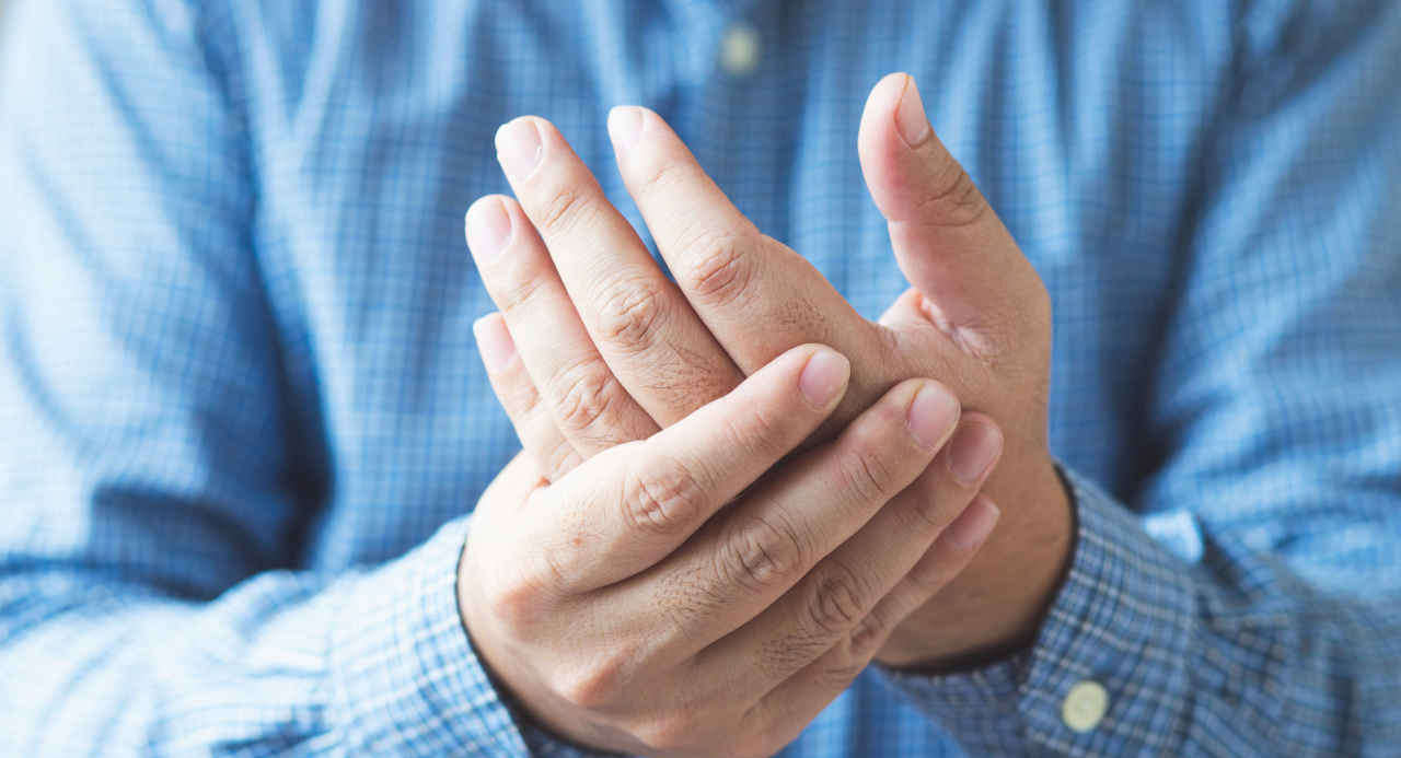 Man with rheumatoid arthritis massaging his hand