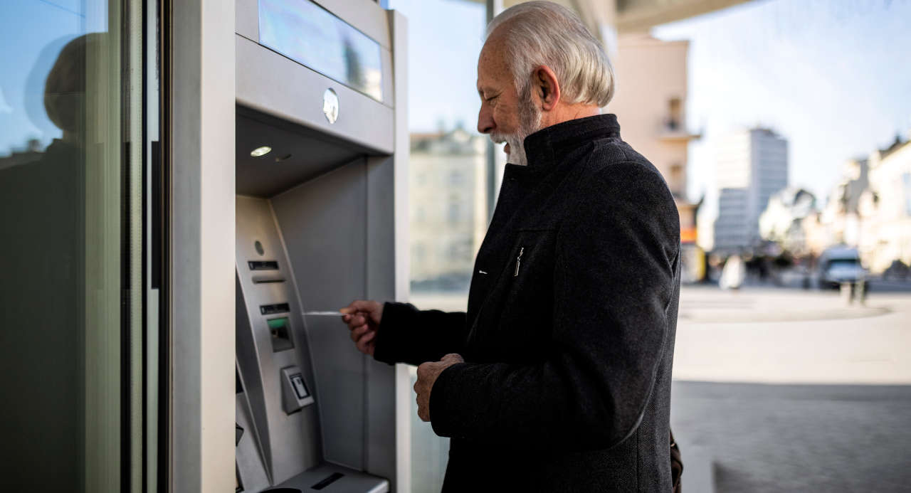 Senior man at ATM machine