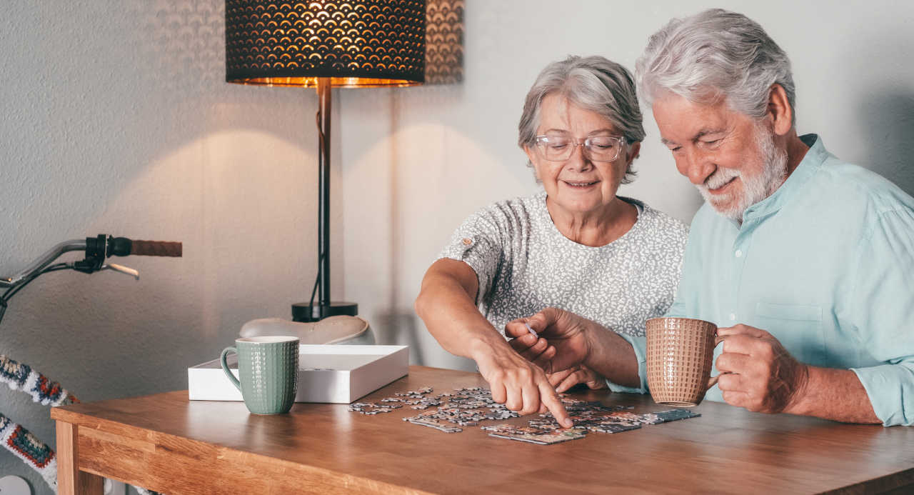 Senior couple engaging in mind-stimulating activities by working on a jigsaw puzzle