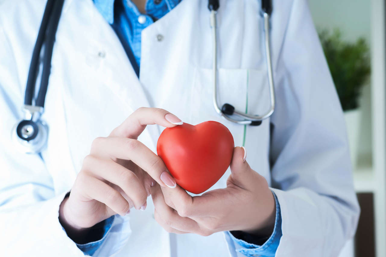 Female doctor holding red toy heart