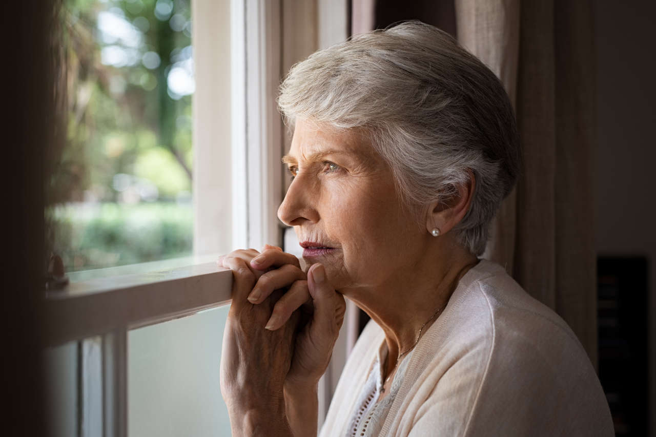 Depressed senior woman looking out the window