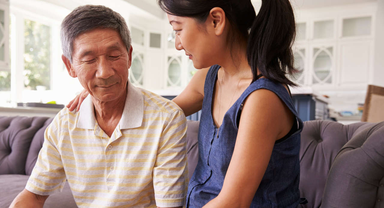 Adult daughter comforting father with Alzheimer’s disease