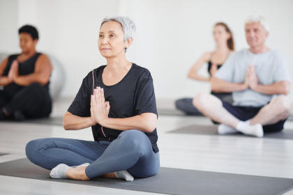 Mature woman doing yoga in class