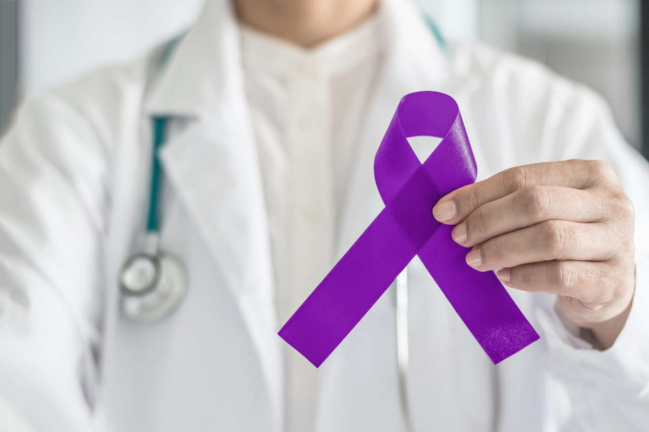 Doctor holding purple ribbon for awareness of seizure disorders