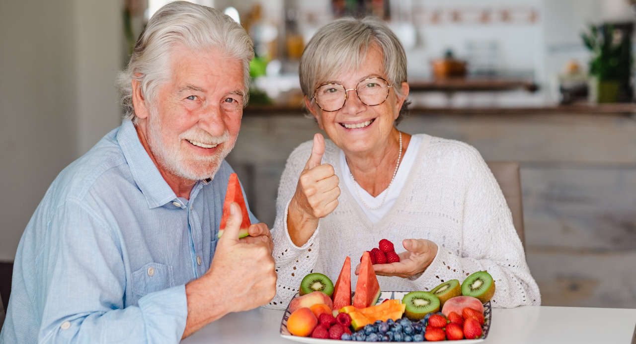 Senior couple enjoying a variety of fruits to take advantage of their health benefits