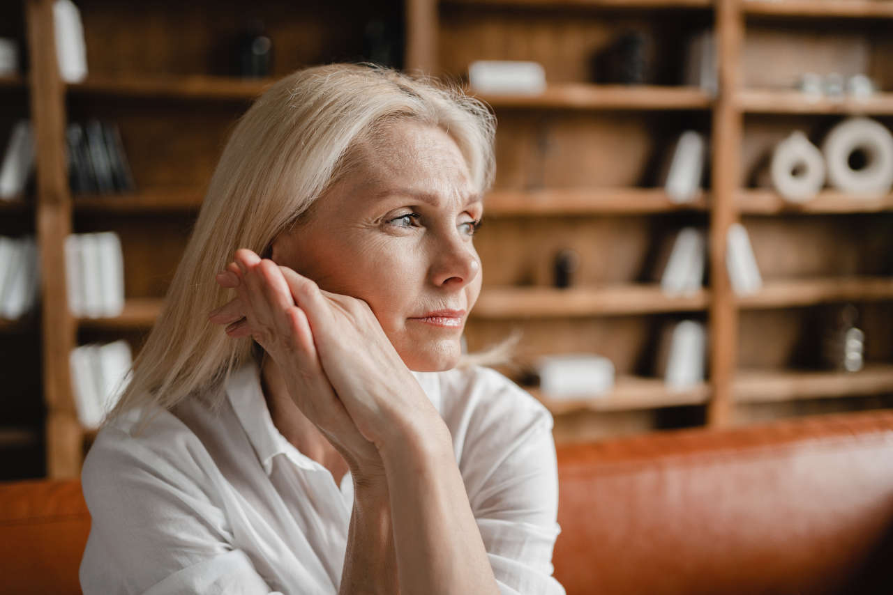 Woman with menopause sitting on a couch at home