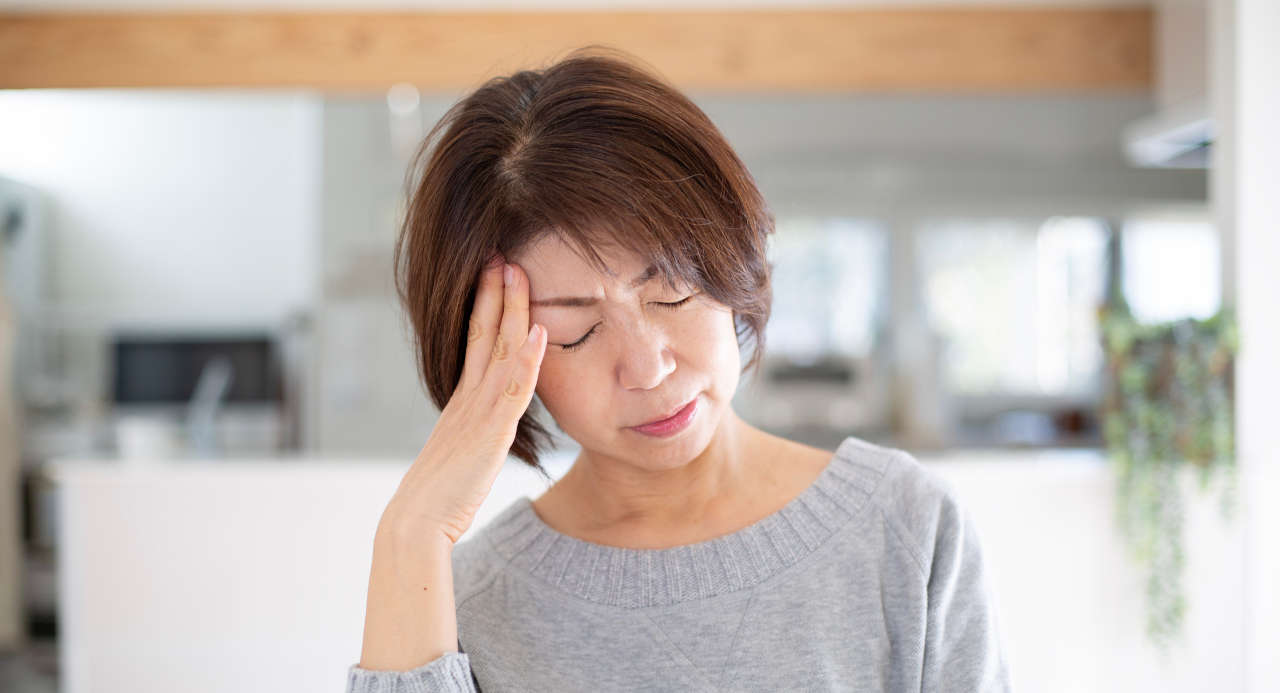 Woman with headache considering migraine treatment options